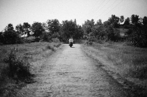 Grayscale Photo of a Person Riding Motorcycle on Road