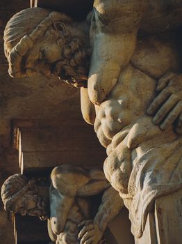 Close-up of muscular stone sculptures in Warsaw, Poland.