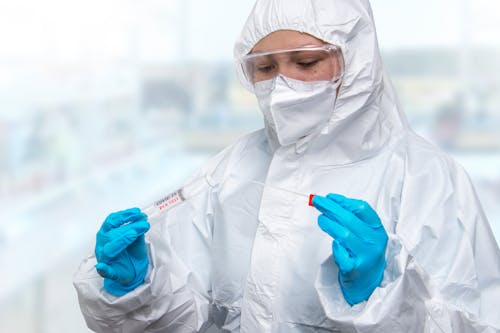 
A Person Wearing a Personal Protective Equipment Testing a Swab