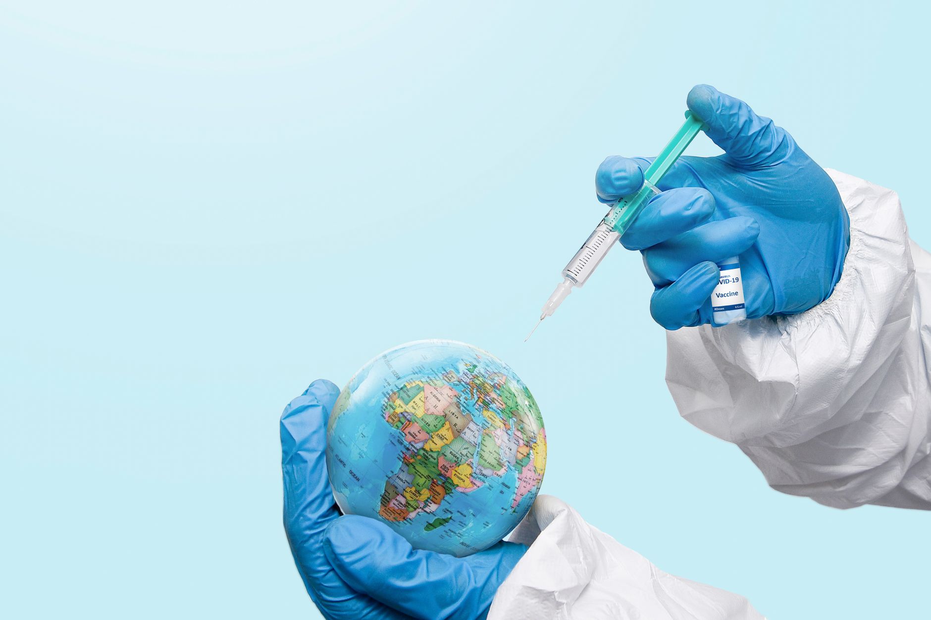 Hands in latex gloves injecting a globe with a syringe, symbolizing global vaccination efforts.