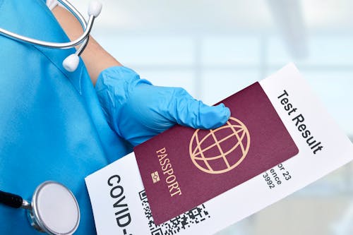 Free A Close-Up Shot of a Medical Professional Holding a Passport and a Test Result Stock Photo