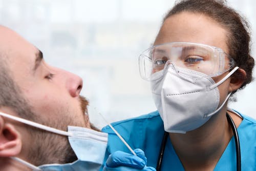 Free 
A Medical Professional Swabbing a Patient Stock Photo
