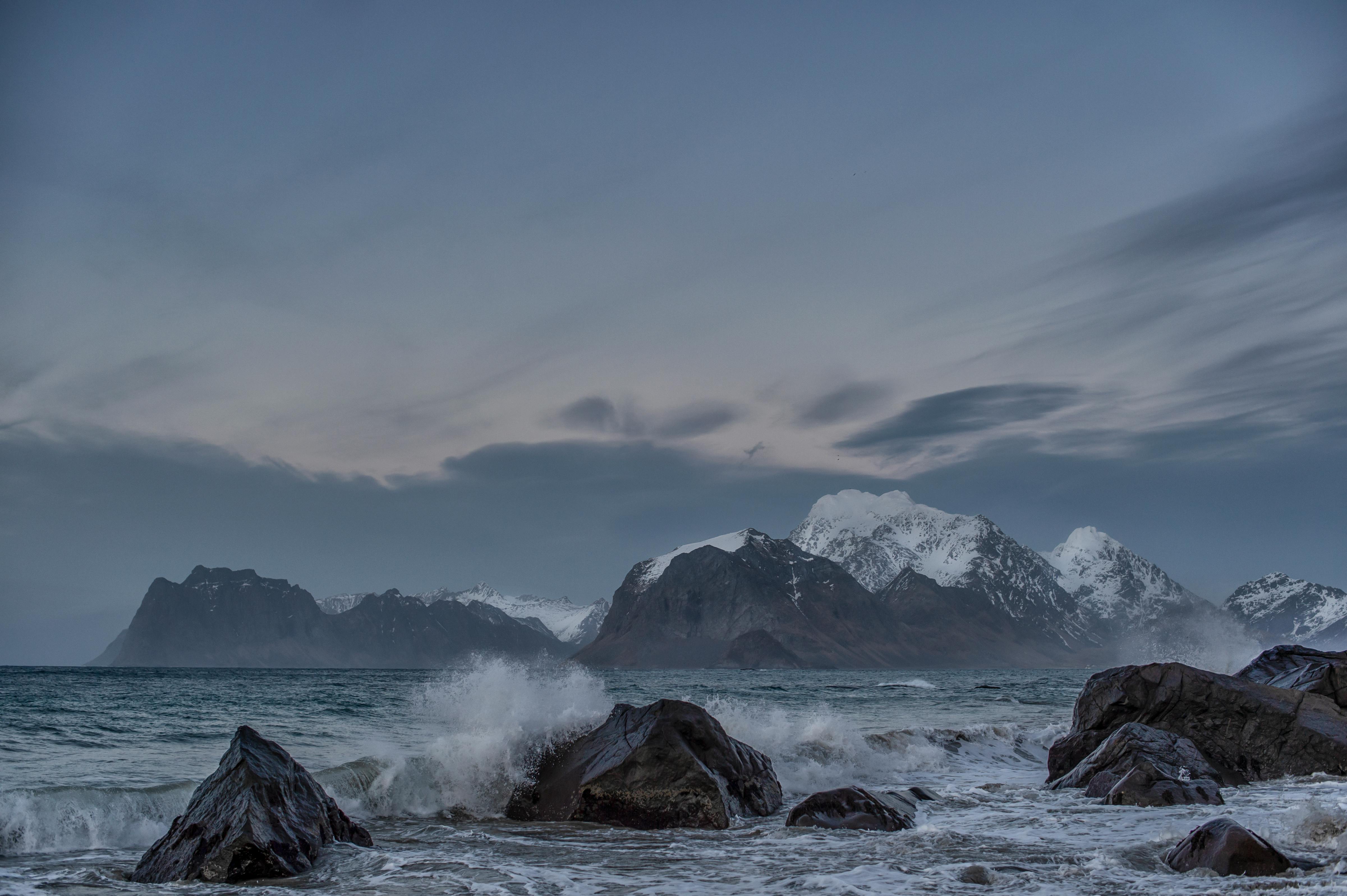 snow covered mountain near body of water