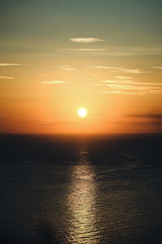 Stunning sunset over the ocean with vivid reflections on water, capturing serene and tranquil beauty.