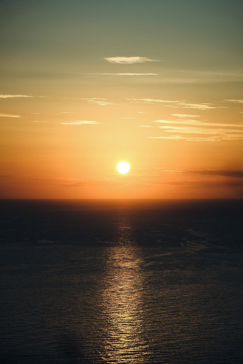 Free Stunning sunset over the ocean with vivid reflections on water, capturing serene and tranquil beauty. Stock Photo