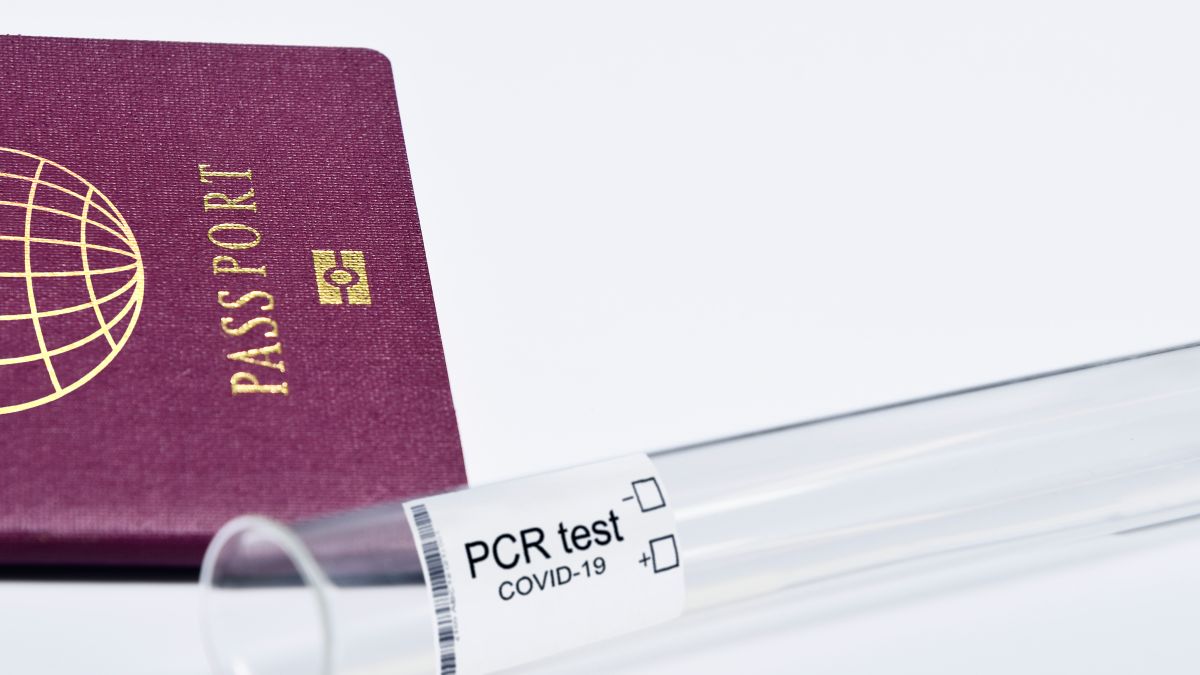 Close-up of a passport and PCR test for COVID-19 depicting travel and health safety measures.