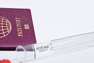 Passport Near a Test Tube on White Surface
