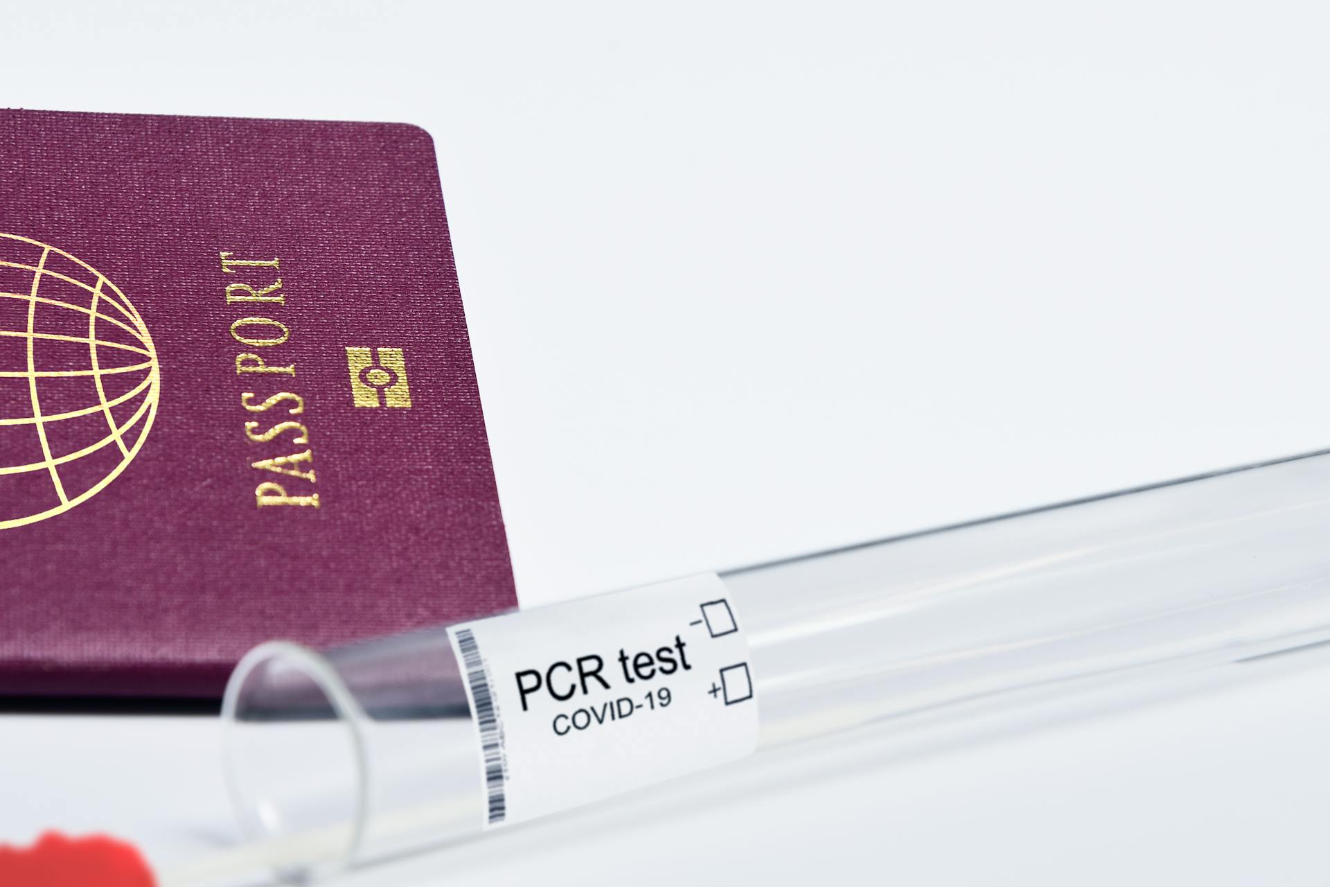 Close-up of a passport and PCR test for COVID-19 depicting travel and health safety measures.