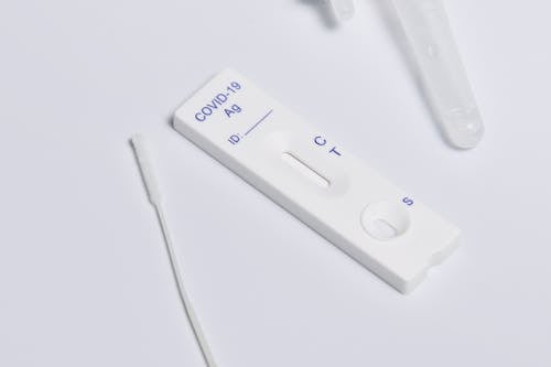 Free Close-up of a COVID-19 rapid antigen test kit showing the testing strip and swab. Stock Photo