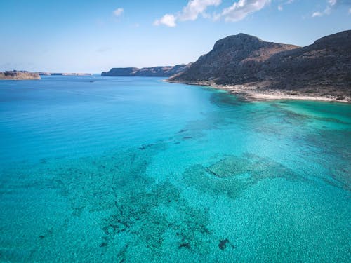 An Aerial Photography of an Ocean Near the Mountain