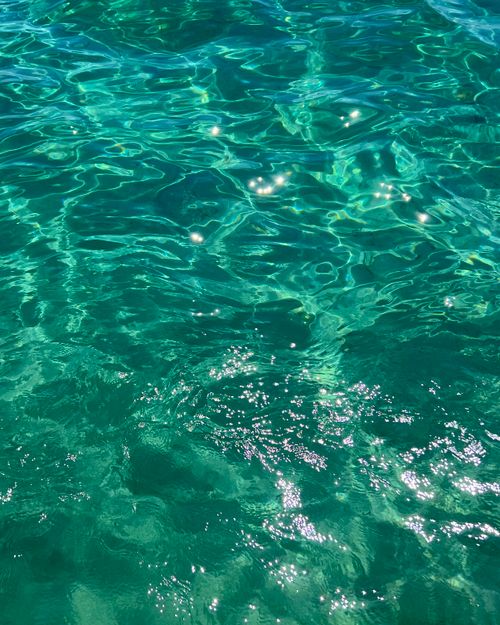 Free Sparkling turquoise water under sunlight with gentle ripples, exuding a tranquil summer vibe. Stock Photo