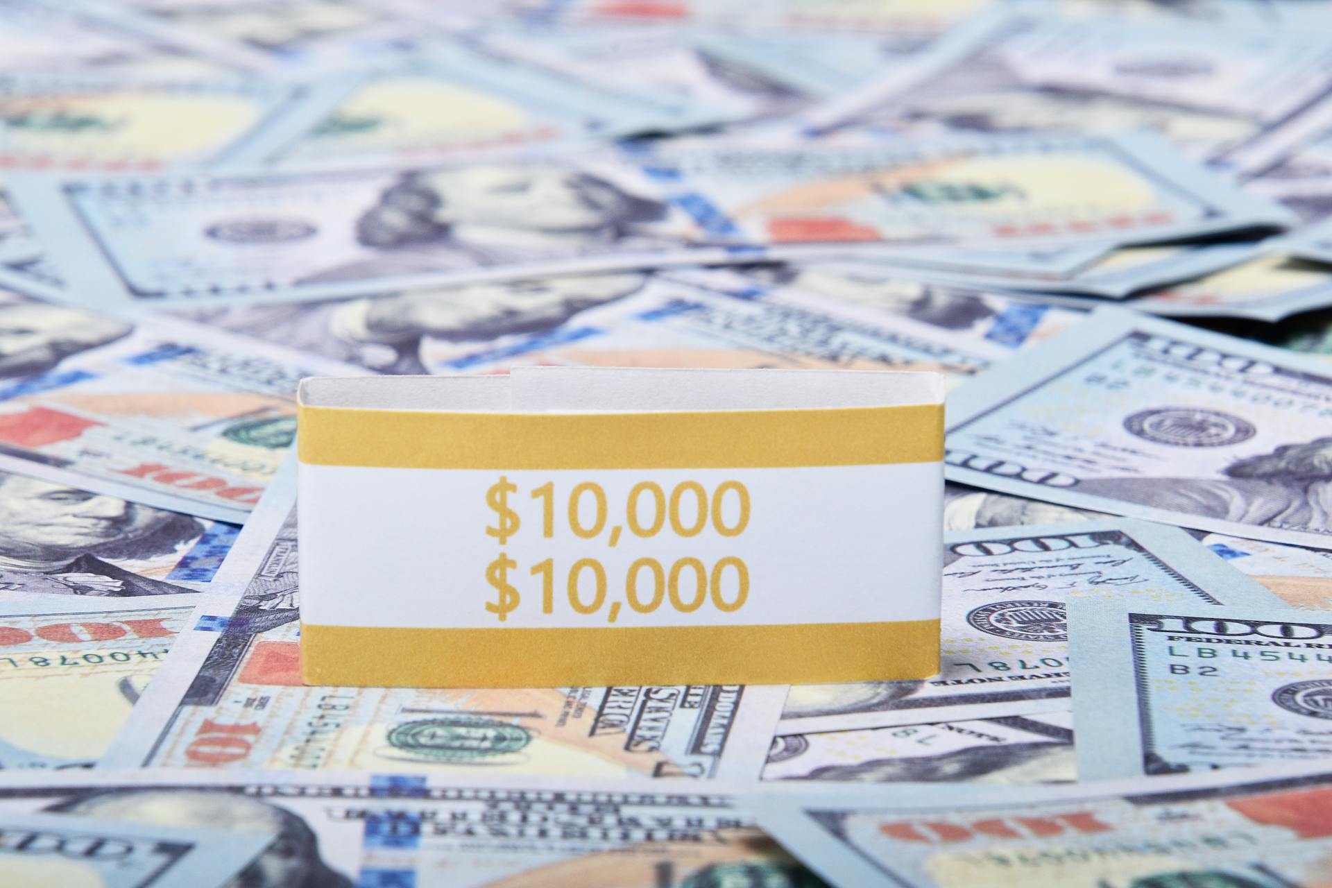 Close-up of US dollar banknotes with a $10,000 money band, ideal for finance and investment themes.