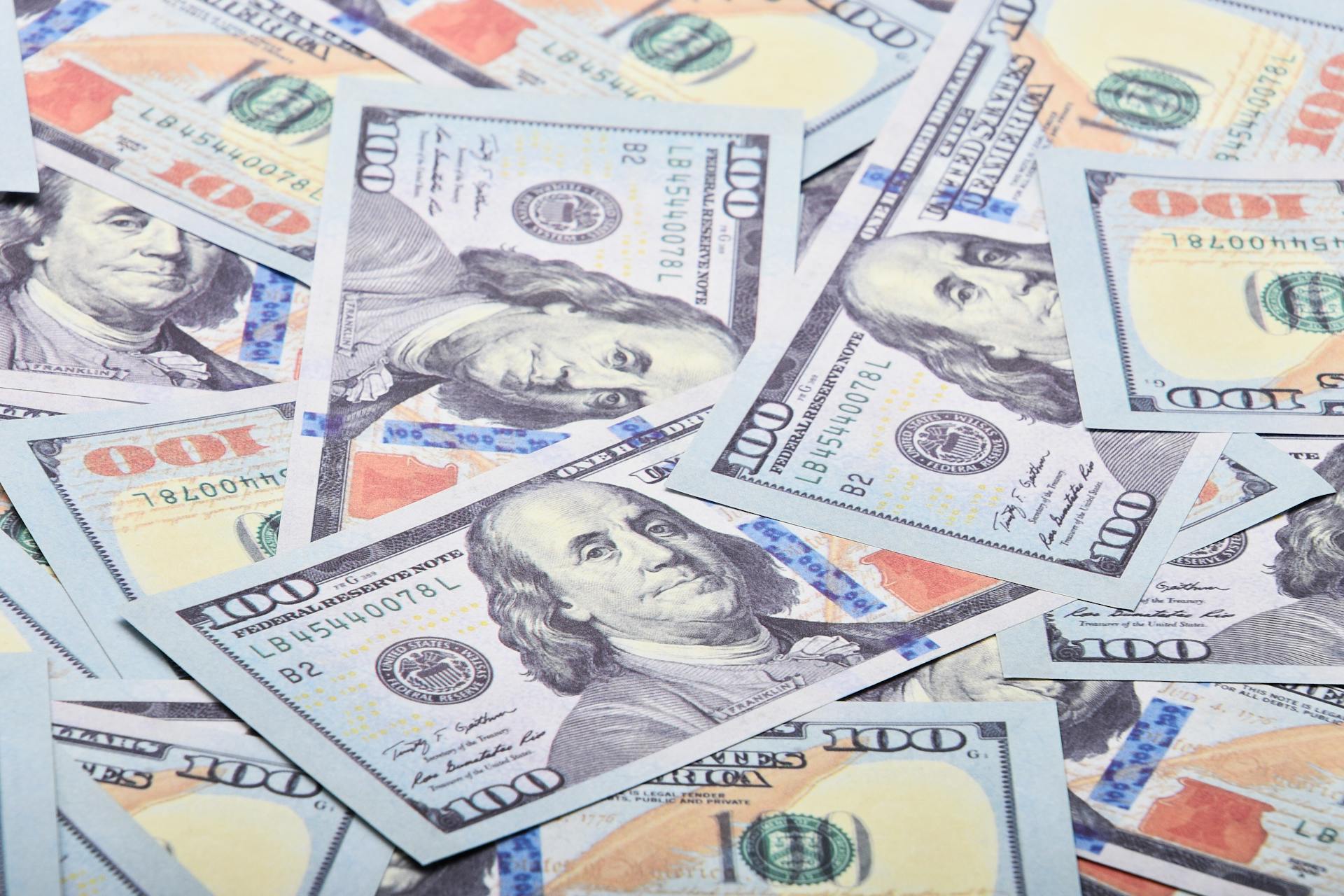 A detailed close-up shot of multiple US dollar bills spread out, showcasing currency detail.