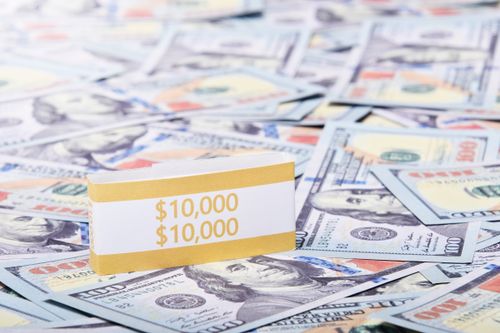 Free Close-up of a $10,000 stack of US dollars with a currency band, highlighting wealth and finance. Stock Photo