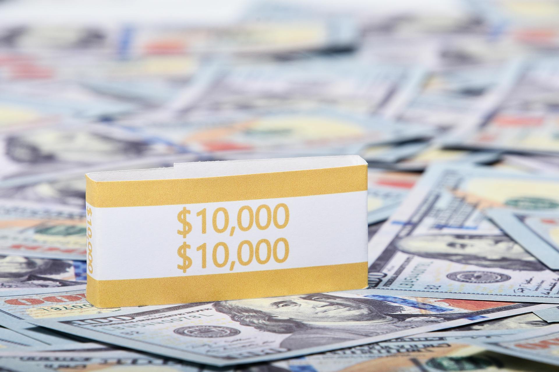 Close-up image of a stack of US dollars with a $10,000 band, symbolizing wealth and finance.