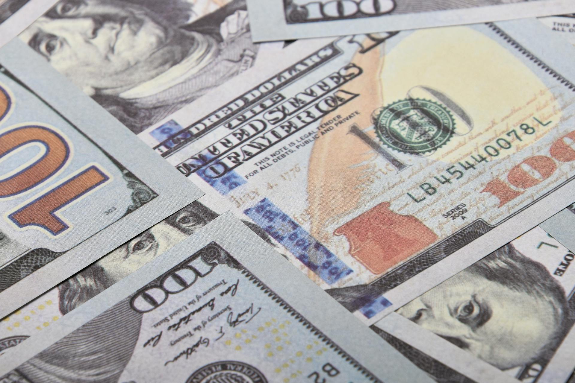 Detailed close-up of multiple US dollar banknotes showing currency details and design.