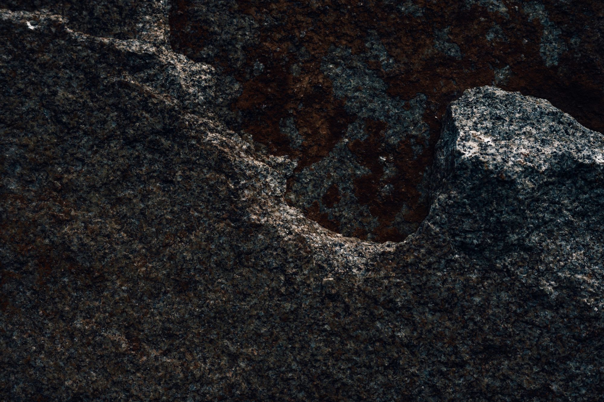 Detailed texture of granite rock surface, highlighting natural formation and erosion.
