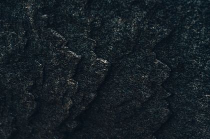 Weathered dark rock detail — Alfo Medeiros on Pexels