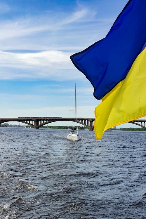 Blue and Yellow Flag on Body of Water 