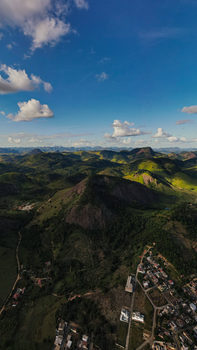 Stunning aerial shot of Mantena's rolling hills and vibrant town under a bright blue sky.