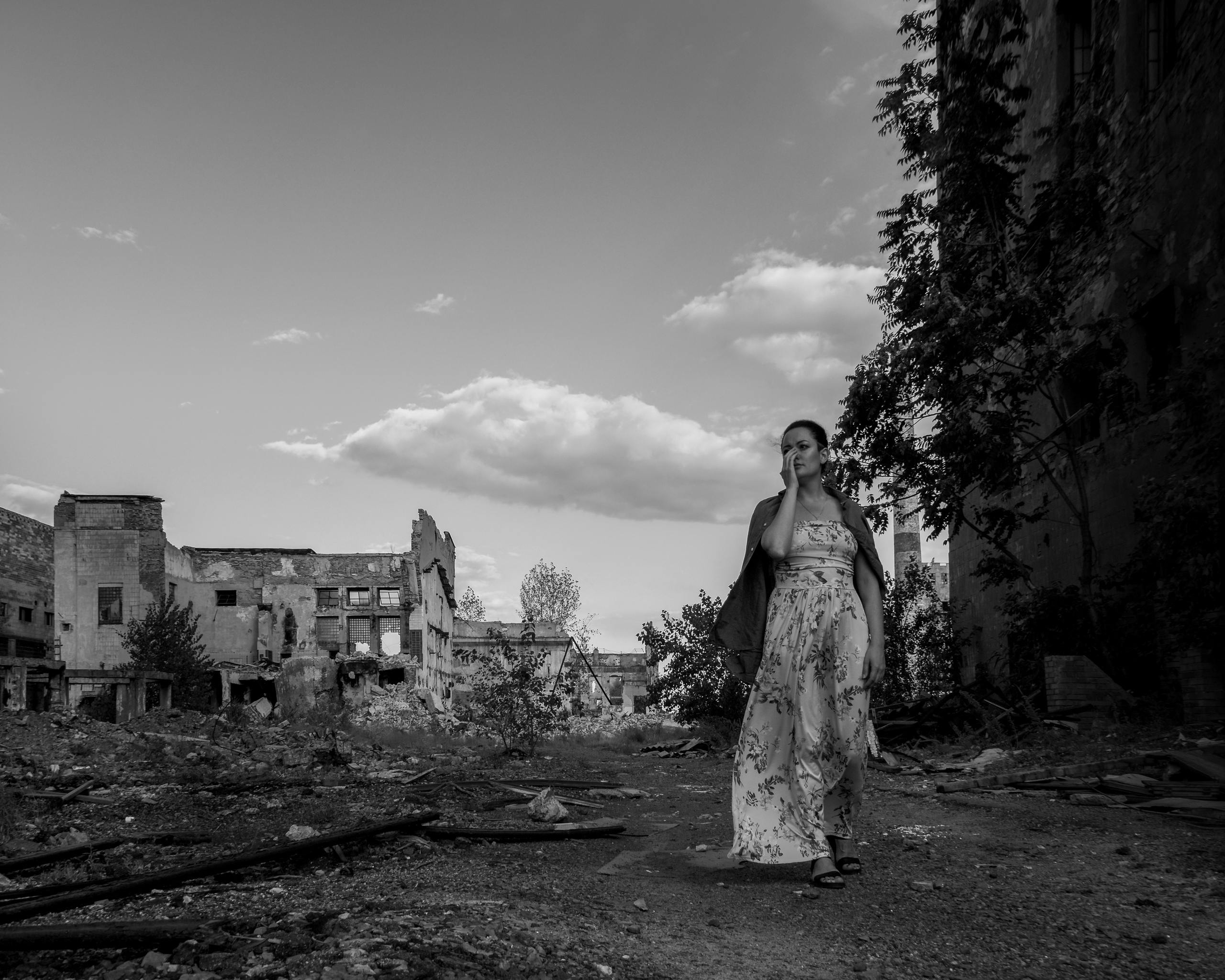 A woman walks through the ruins of Donetsk, Ukraine, symbolizing resilience amidst destruction.