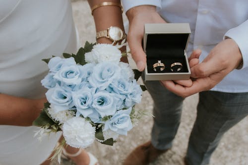 Couple Holding Flowers and Wedding Ring