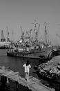Black and White Photo of a Woman Standing on Wooden Dock