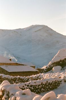 Breathtaking snow-covered mountains during sunset in a serene winter setting.