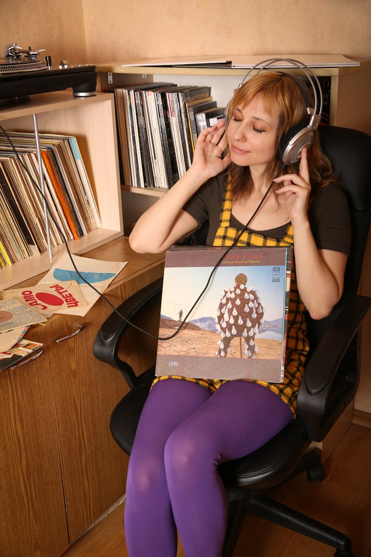 Woman Sitting On Armchair And Listening To Music