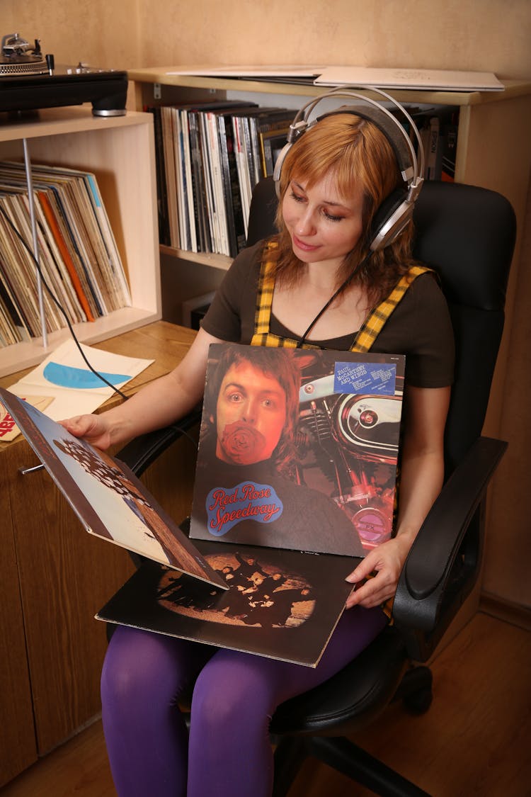 Woman Looking At Albums And Listening To Music