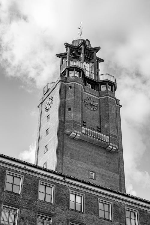Grayscale Photo of a Clock Tower under the Cloudy Sky