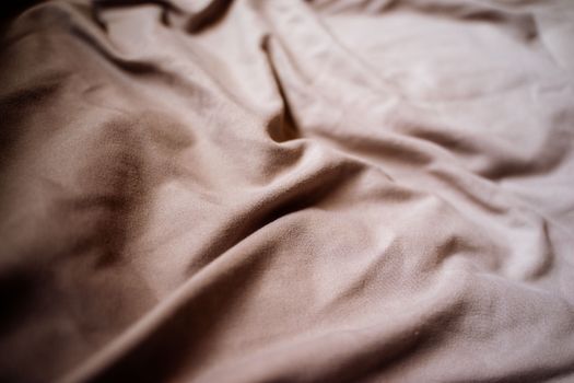 A close-up view of a beige fabric showcasing soft textures and natural shadows.