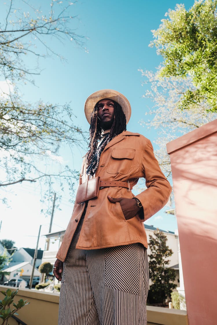 Man With Long Dreadlocks Posing In Leather Jacket And Striped Pants