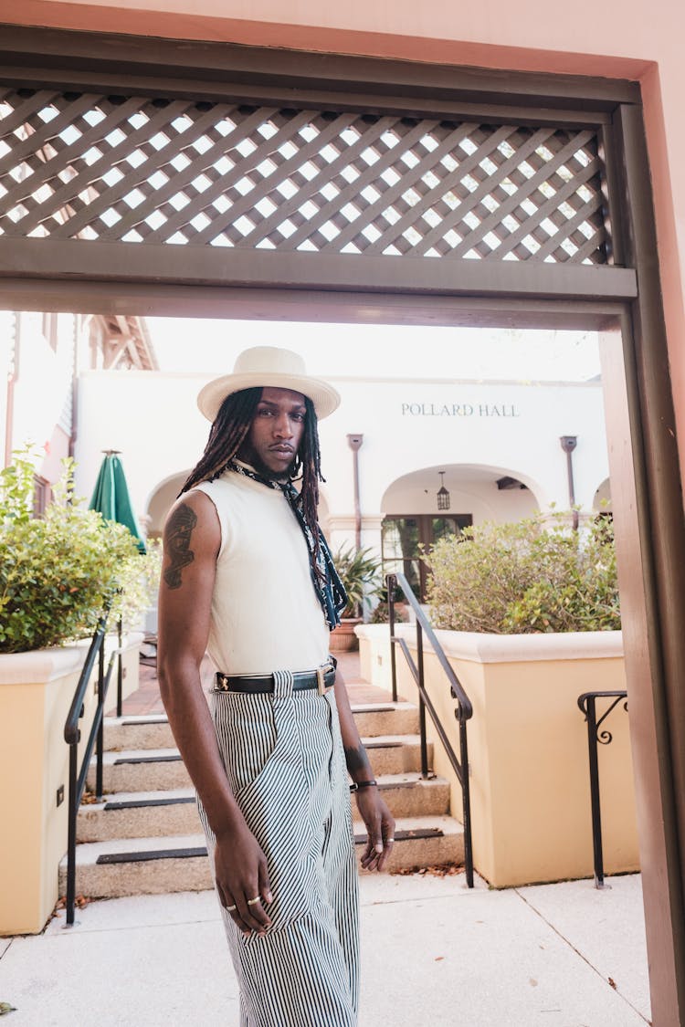 Man With Long Black Dreadlocks Standing In Entrance To Restaurant Garden