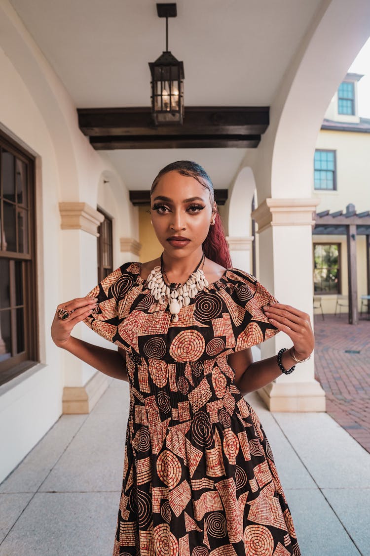 Woman With Strong Makeup And Frilled Dress In Ethnic Style Standing Under Arcades