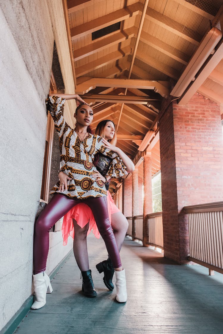 Two Women Posing With Gestures For Fashion Photo On Balcony 