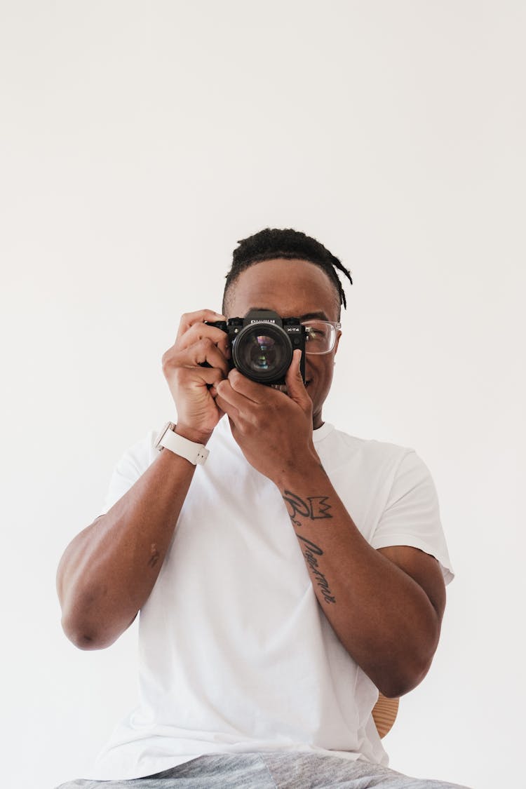 Man In White Shirt Taking Photo With A Camera