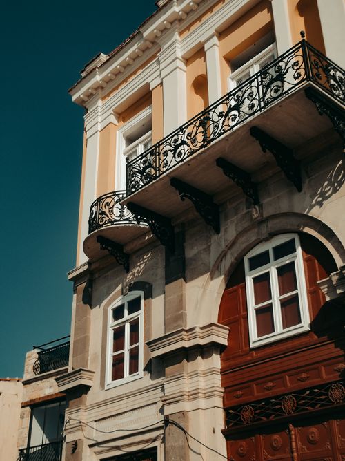 Free Low-angle view of a historic building with ornate balconies against a clear sky. Stock Photo