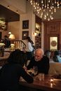 Man in Black Sweater Sitting Beside Woman in White Long Sleeve Shirt