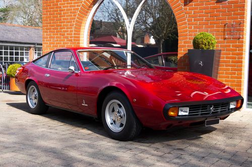 Free A classic red sports car parked outside an English manor, showcasing luxury and historical design. Stock Photo