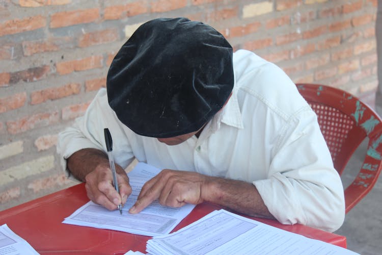 Close Up Photo Of Man Writing On Paper With A Pen