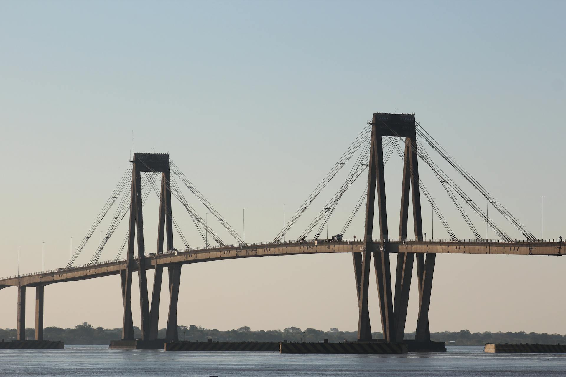 A breathtaking shot of the General Manuel Belgrano Bridge in Argentina, spanning over a calm river.