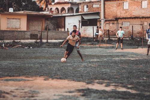Free People Playing Soccer on Field Stock Photo