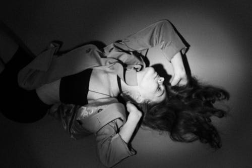 Black and White Photo of a Woman Lying Down on the Ground