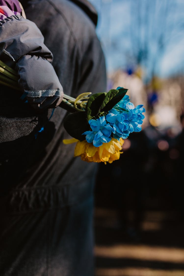 Holding Blue And Yellow Flowers