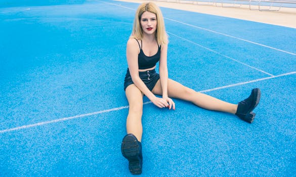 一位金发女子放松地坐在户外充满活力的蓝色网球场上