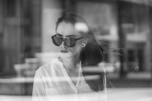 Фотография женщины через стеклянное окно в оттенках серого