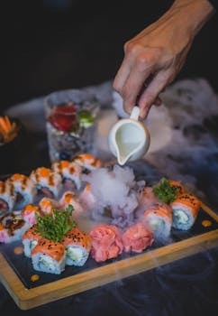 将酱汁倒在寿司卷上，用手产生迷人的烟雾效果