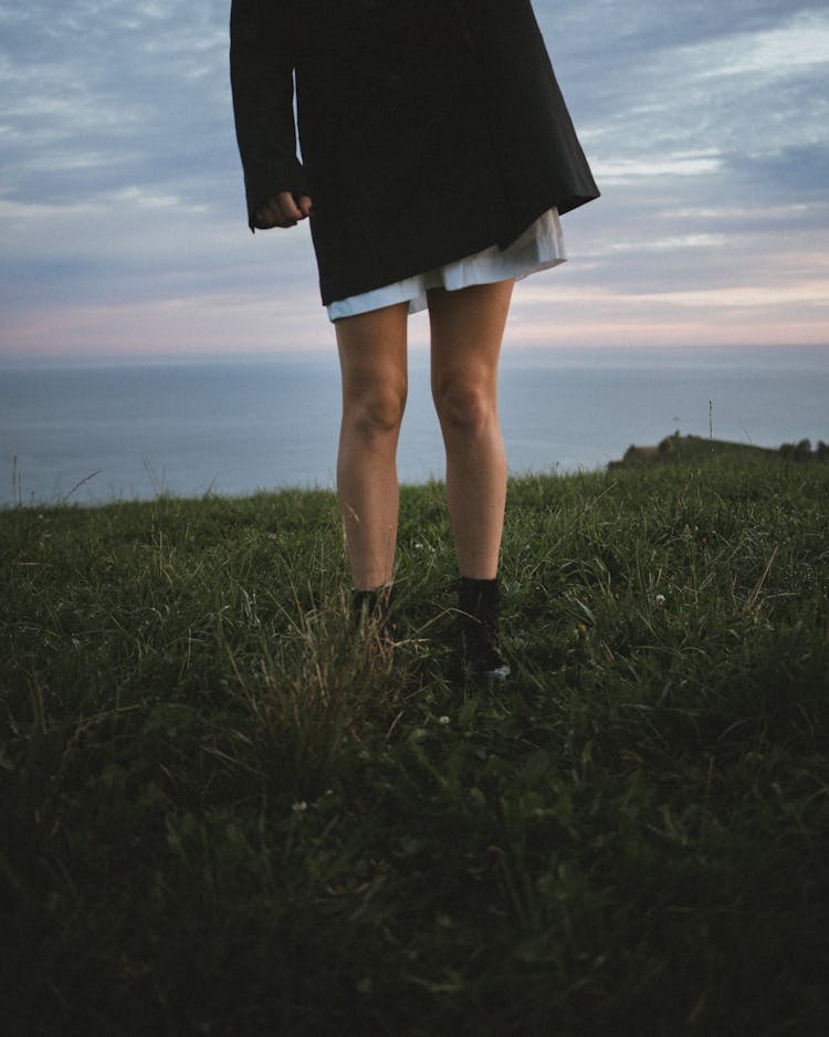 Woman In Dress And In Dr. Martens Standing On Field