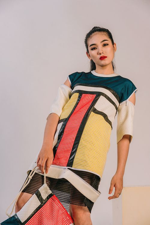 Free Stylish young woman in colorful modern outfit posing indoors. Stock Photo